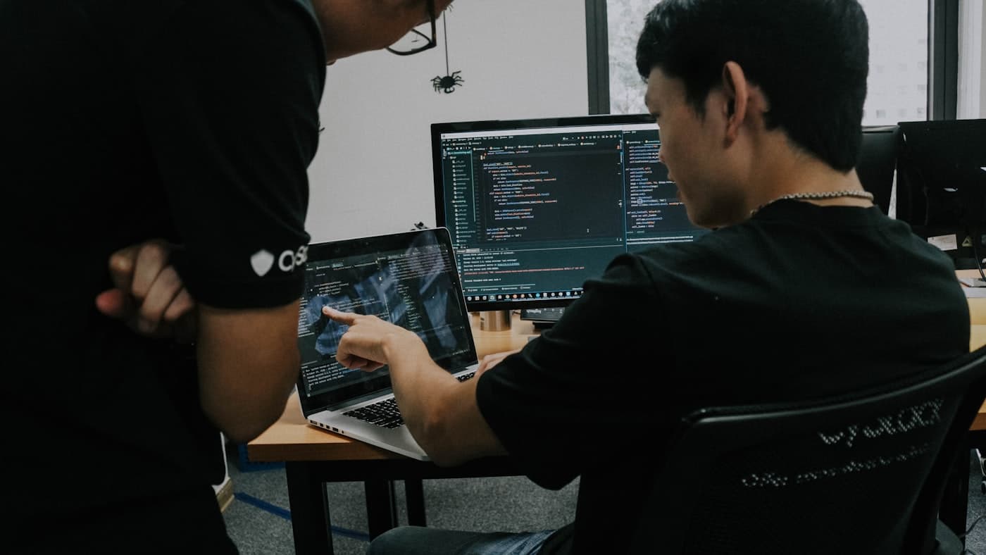 Two DevFixel engineers reviewing code together on a laptop